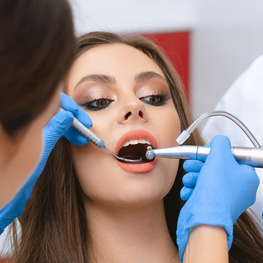 пациент на процедуре профессиональной чистки зубов