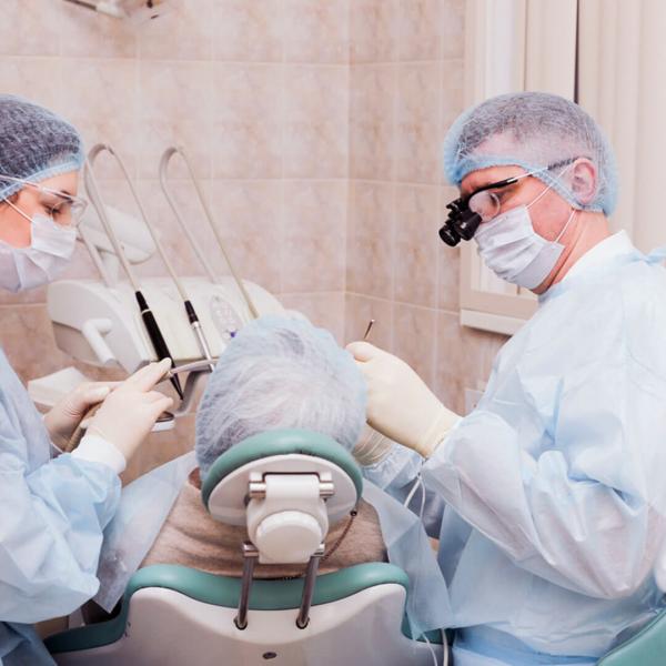 фото стоматолога, его ассистента и пациента уже в процессе операции синус-лифтинга