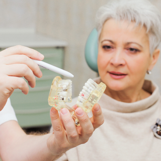 врач-ортопед помогает выбрать лучший протез на все зубы