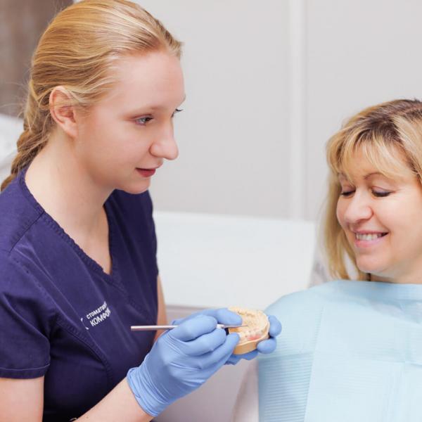 фото стоматолога, который объясняет пациенту процесс костной пластики